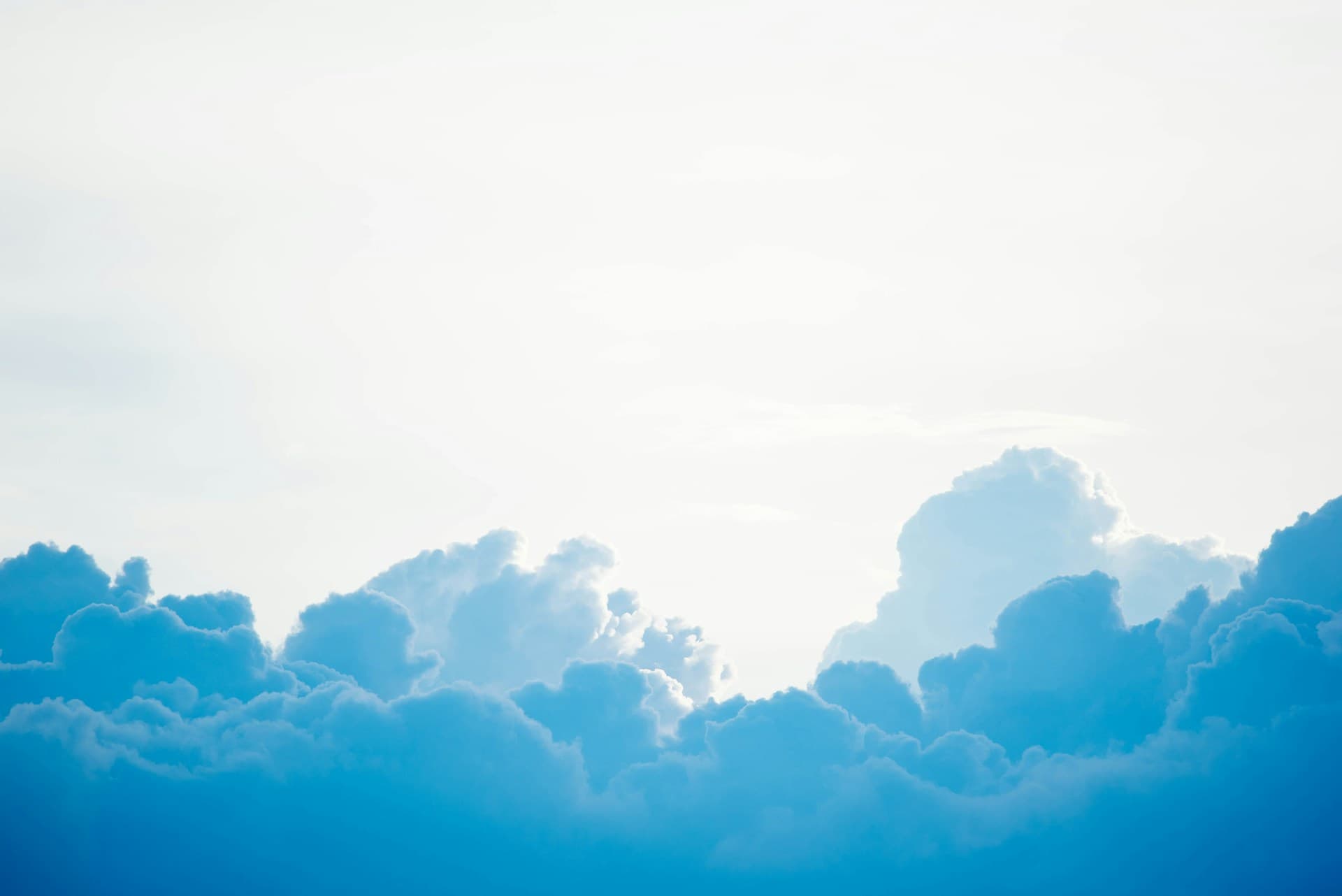 Blue clouds against a bright sky, symbolizing the cloud as a hosting platform for websites and web apps