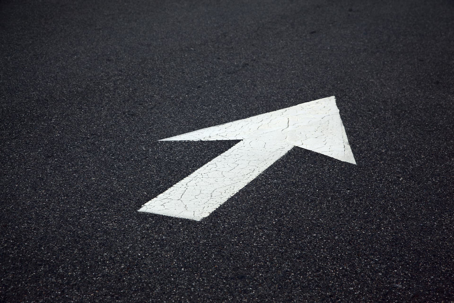 Painted arrow on asphalt pointing forward, symbolizing context routed through a compression layer